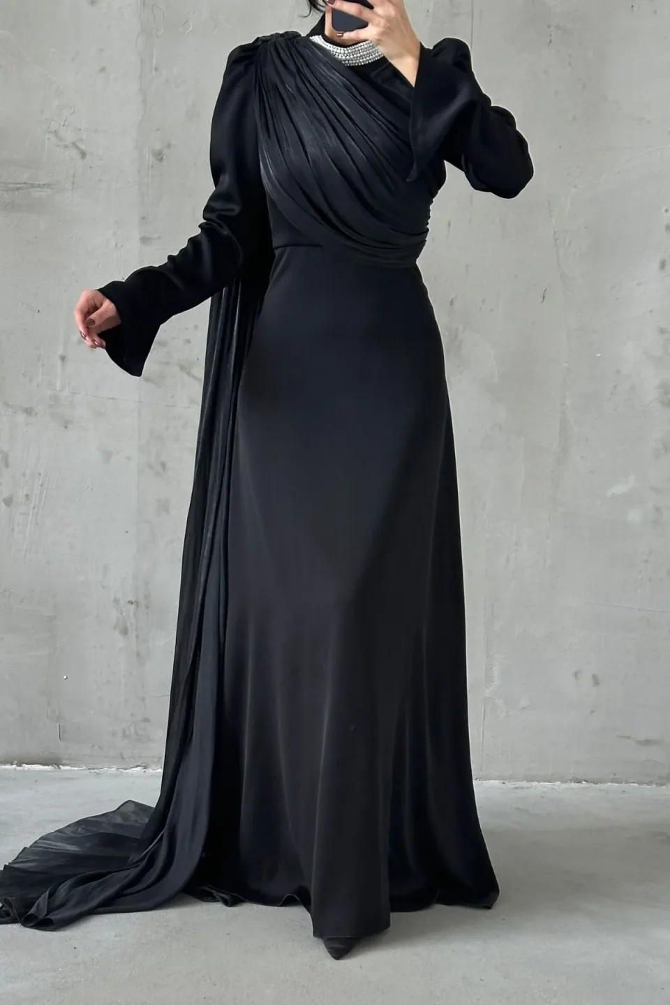 Elegant maxi dress with draped detailing and long sleeves in a soft, muted tone.
